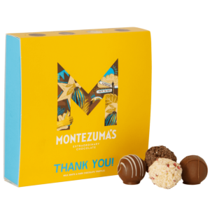 Thank you printed truffle box. A baby blue box with a yellow sleeve wrapped around it, printed with the Montezuma's Logo and large 'M' with cocoa bean graphics inside 
